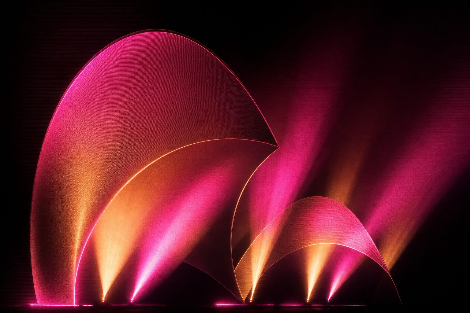 Overlapping curved architectural shells lit from below, with light following the curvature.
