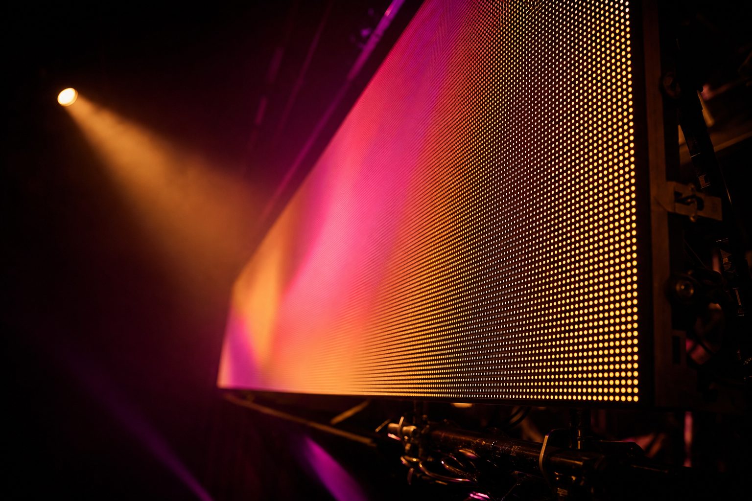 An LED panel photographed at an oblique angle, the individual diodes resolving into a regular grid near the lens and blurring into a smooth image further away.