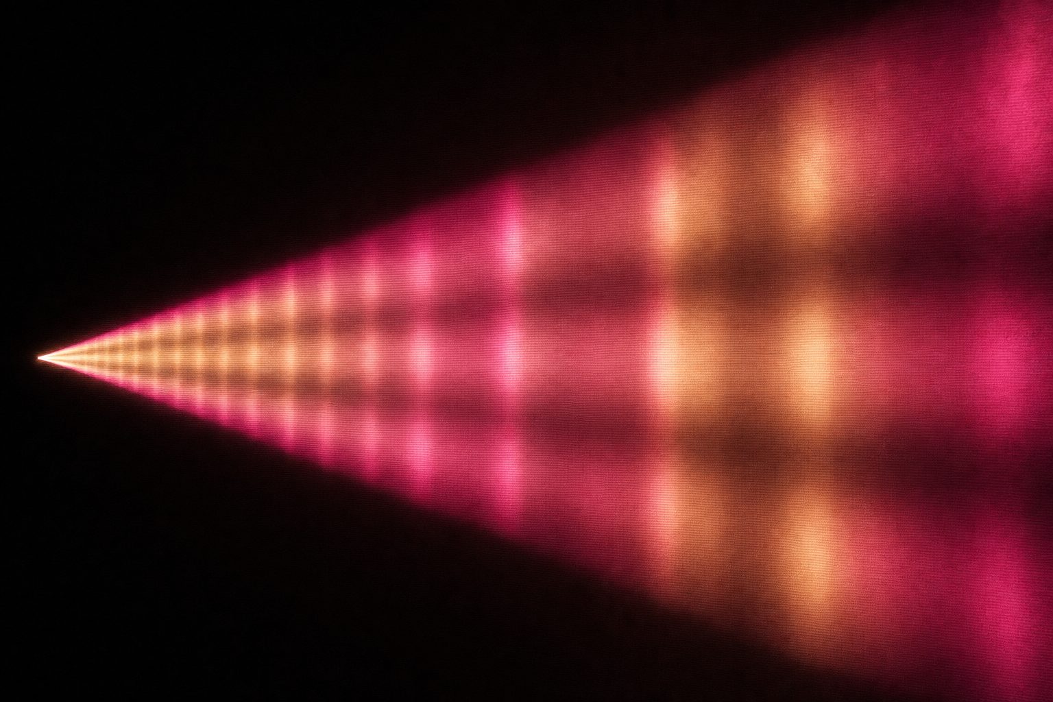 A single wide cone of light opening from a point at the left edge of the frame toward the right, crossed at regular intervals by faint bands of haze so the cone reads as measured distance.